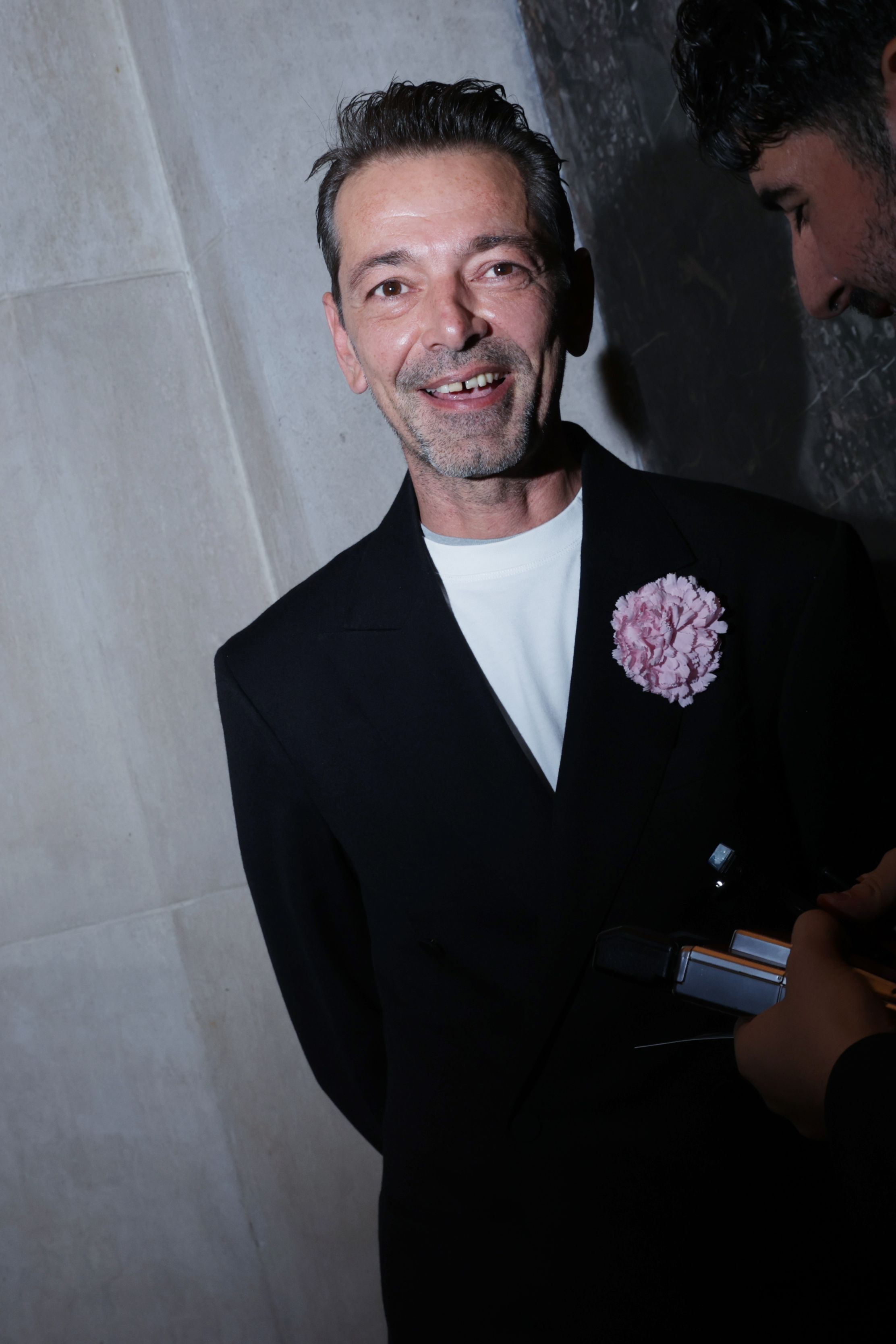 Image may contain Blazer Clothing Coat Jacket Face Head Person Photography Portrait Formal Wear Suit and Happy